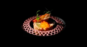 Tartar de salmón con huevas de pescado sobre fondo negro