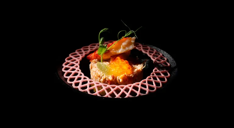 Tartar de salmón con huevas de pescado sobre fondo negro
